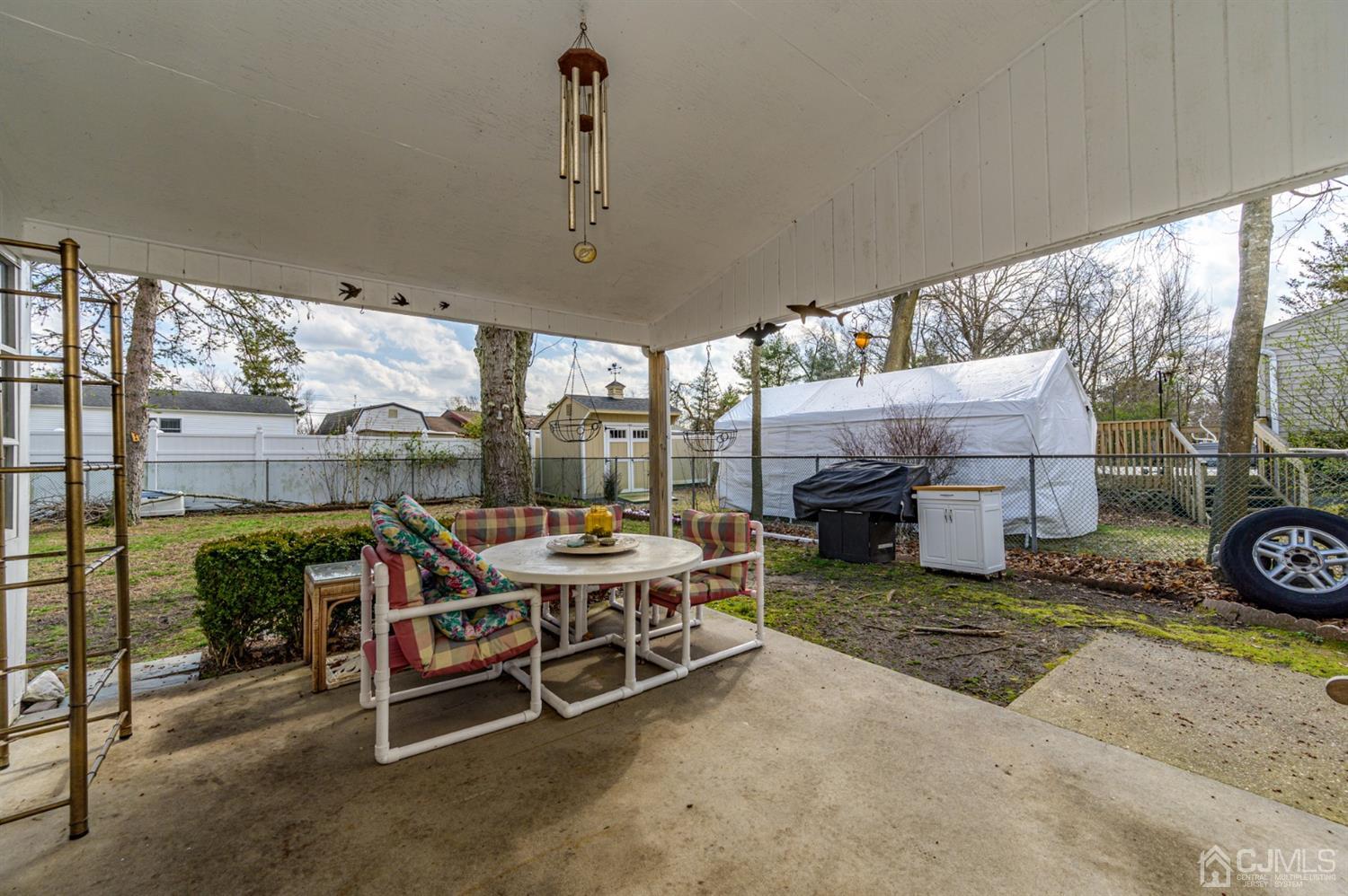 456 Dover Road Toms River, NJ 08757 - Photo 35 of 39 a view of a patio with table and chairs potted plants with wooden floor
