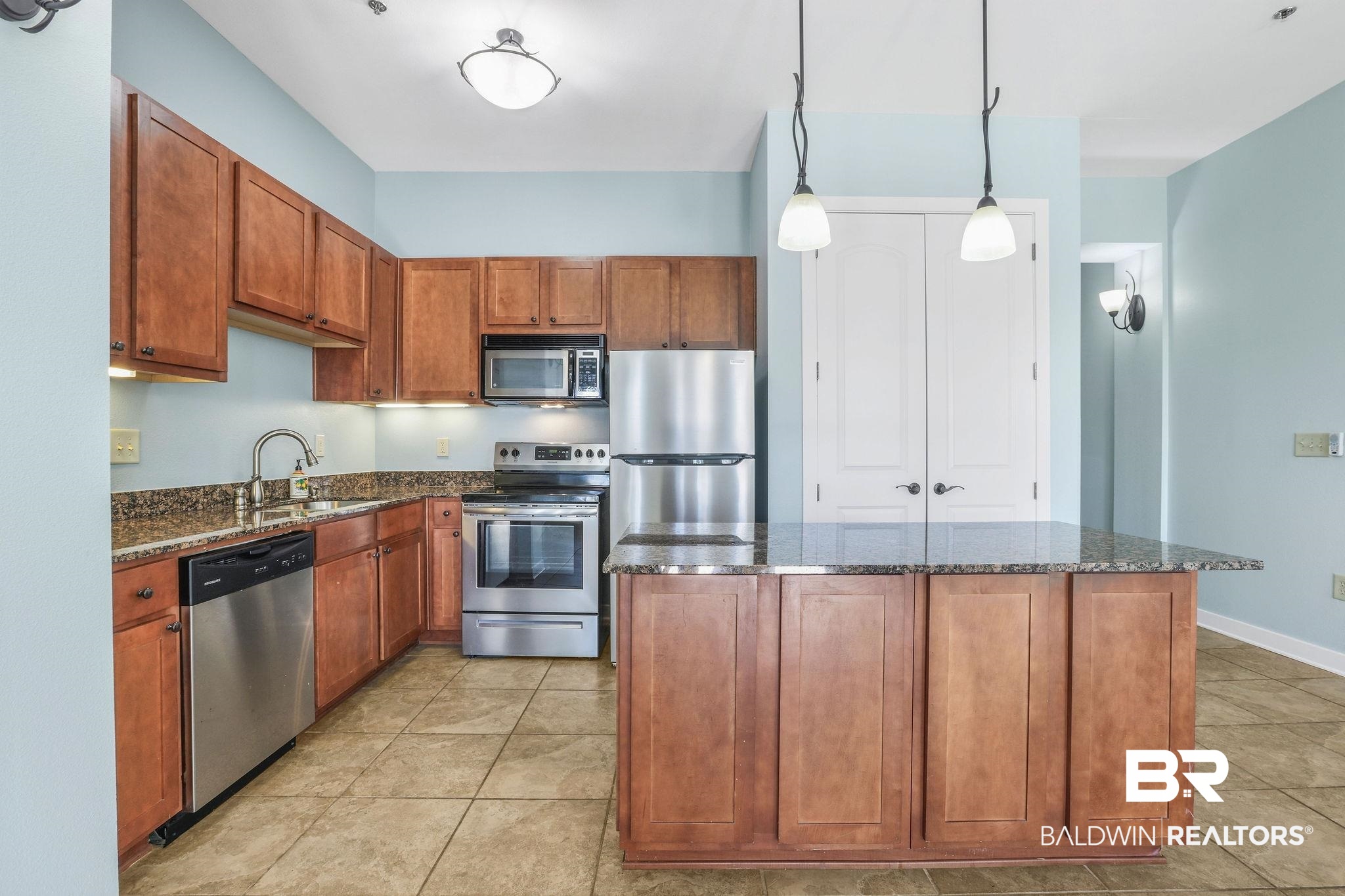 1430 Regency Road, Unit B302 Gulf Shores, AL 36542 - Photo 8 of 24 Kitchen featuring a center island, dark stone countertops, stainless steel appliances, and a sink