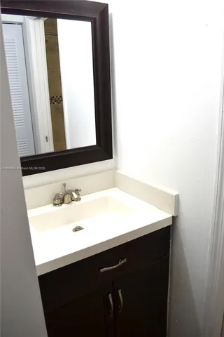 a bathroom with a sink vanity and a mirror