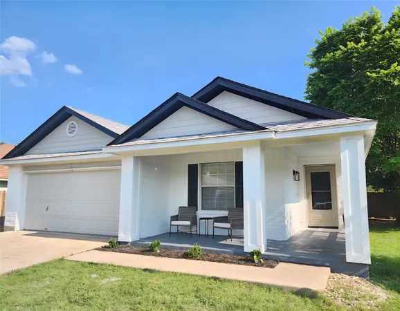 a view of house with yard and outdoor seating