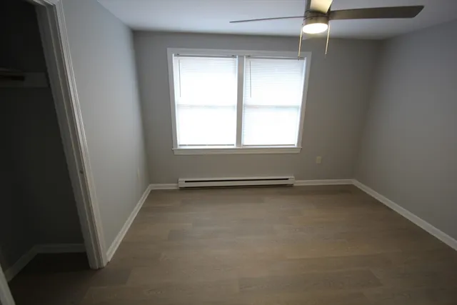 an empty room with closet and a chandelier fan