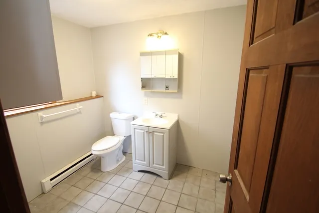 a bathroom with a toilet a sink a vanity and mirror