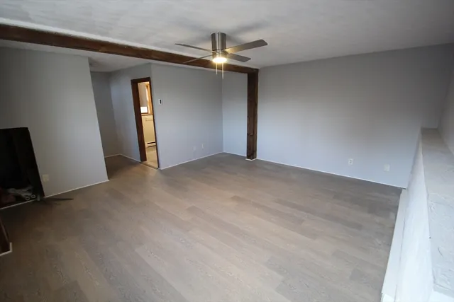 an empty room with closet and a chandelier fan