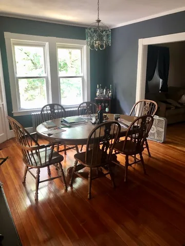 a dining room with furniture a chandelier and wooden floor