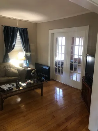 a living room with furniture floor to ceiling window and wooden floor