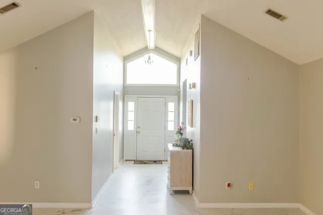a view of a hallway with wooden floor and a bathroom