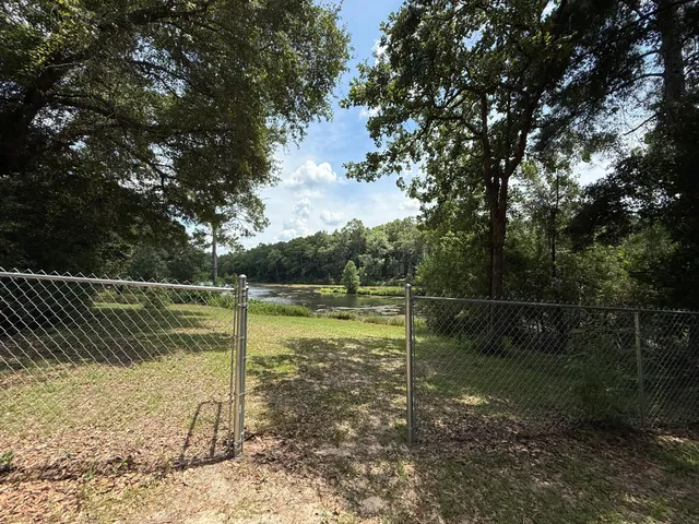 a view of a backyard with table and chairs and a barbeque