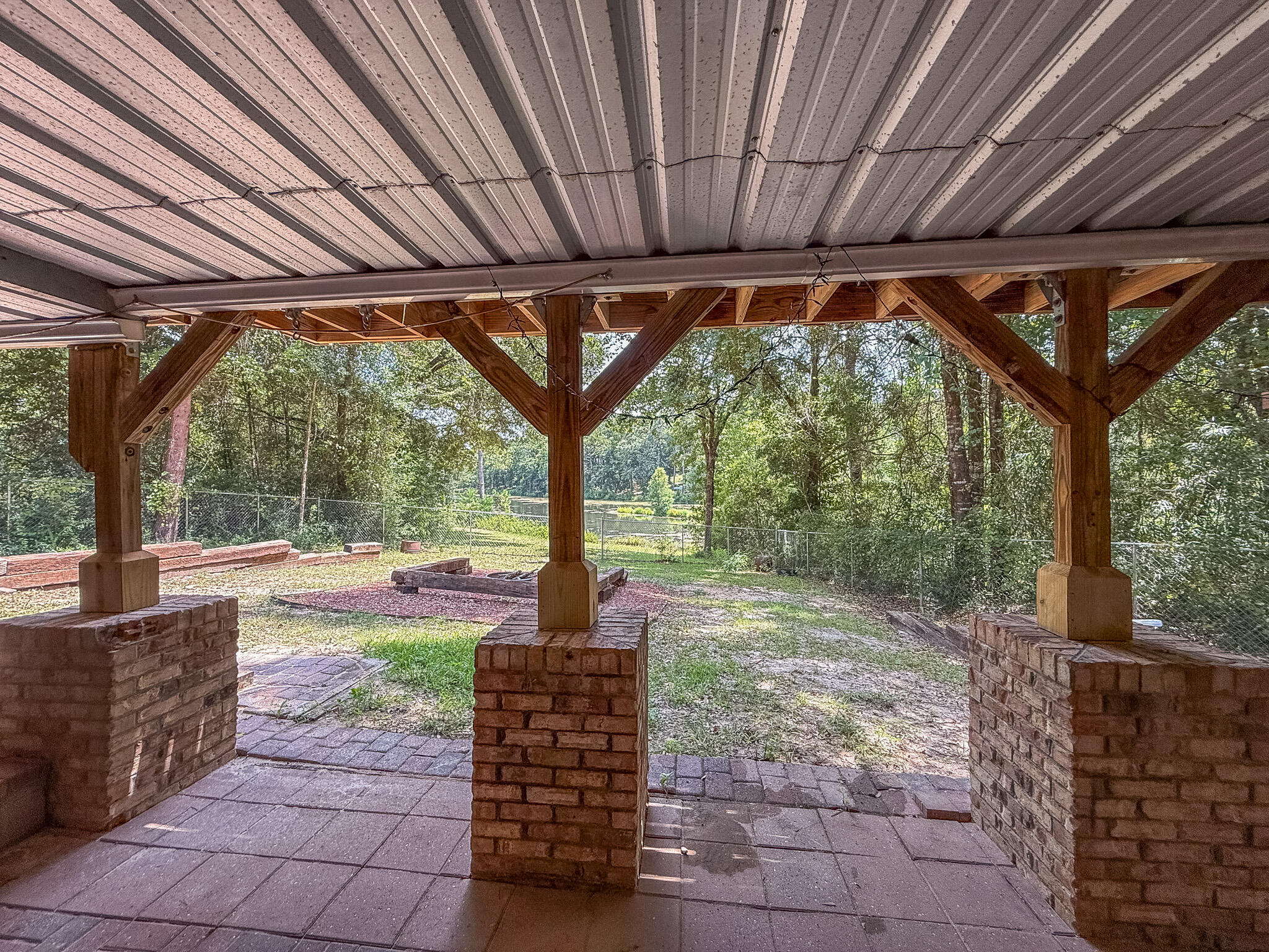 100 Overview Drive Crestview, FL 32539 - Photo 31 of 82 a view of a patio with table and chairs under an umbrella with a big yard
