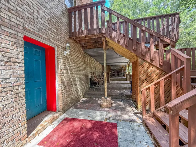 a view of a patio with table and chairs with wooden floor and fence