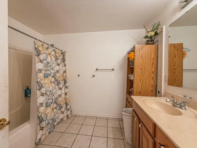 a spacious bathroom with a granite countertop sink a toilet and a shower