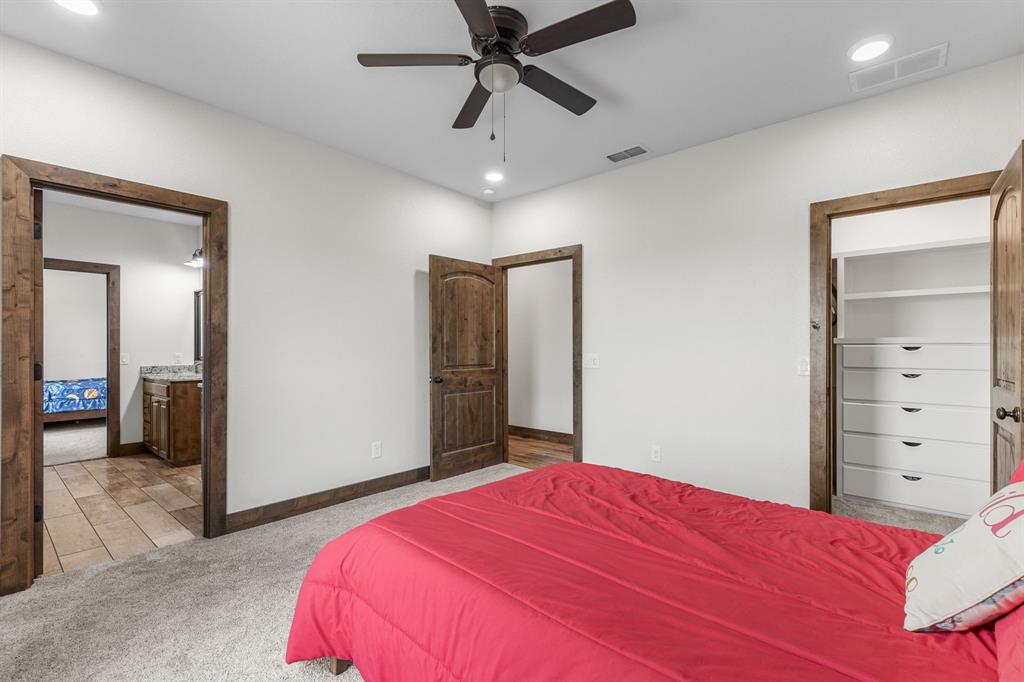 515 Sales Road Windthorst, TX 76389 - Photo 28 of 34 a bedroom with a bed and a chandelier