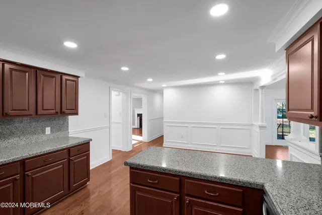 an empty room with windows fireplace and wooden floor