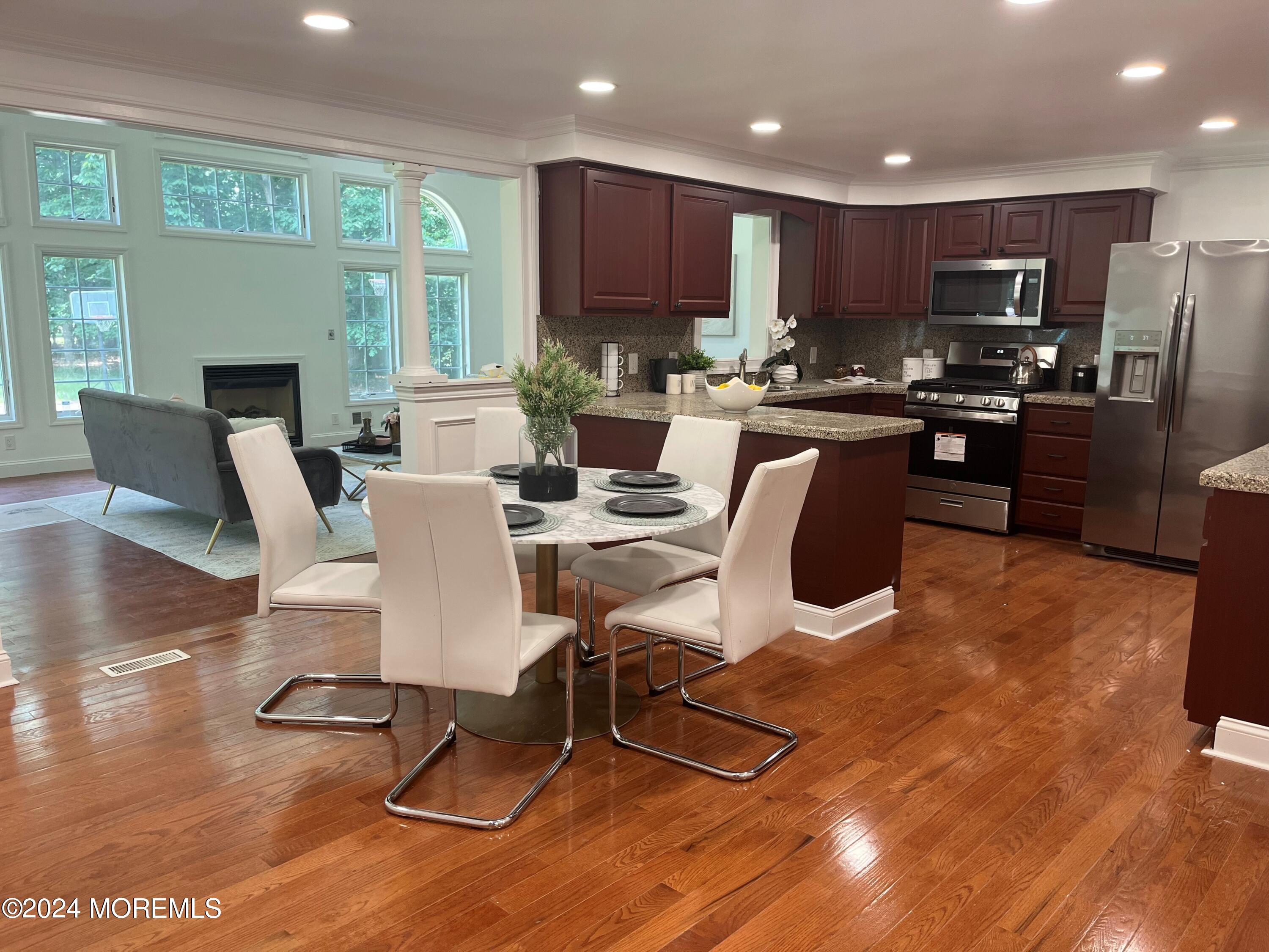 6 Afton Road Jackson, NJ 08527 - Photo 10 of 80 a kitchen with stainless steel appliances granite countertop a refrigerator a stove top oven and a dining table with wooden floor