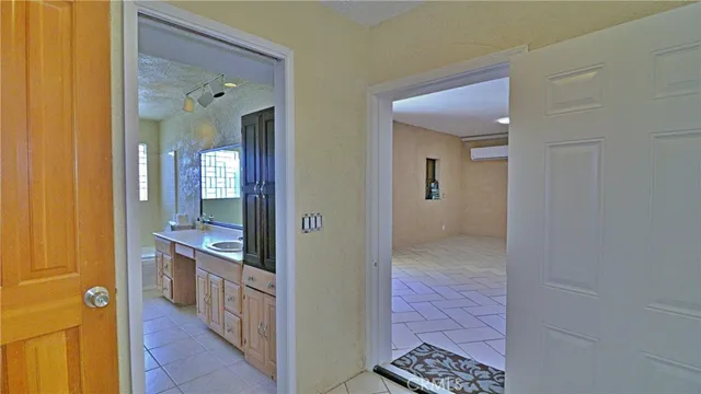 a view of a hallway with wooden floor and a bathroom