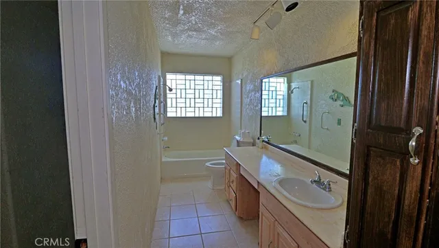 a bathroom with a granite countertop sink a mirror and a bathtub