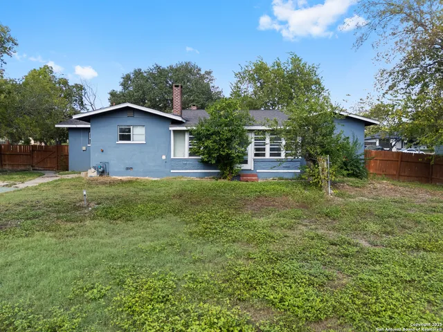 a view of a yard in front of a house with large trees