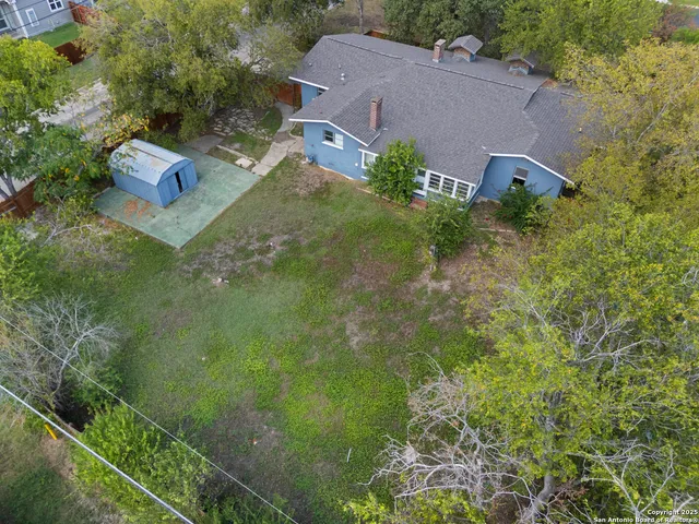 an aerial view of a house with garden space and street view
