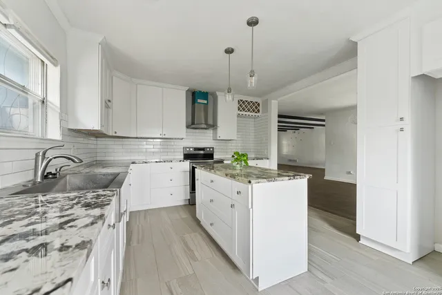 a kitchen with a stove a sink a refrigerator and window