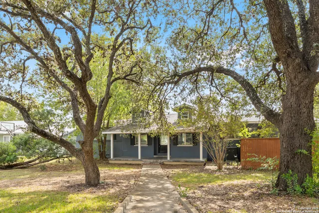 a view of a house with a tree in front of it