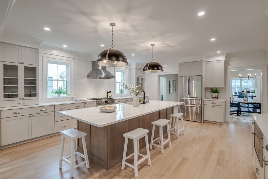 25 Webber Avenue Bedford, MA 01730 - Photo 3 of 42 a kitchen with stainless steel appliances kitchen island granite countertop a table chairs sink and cabinets