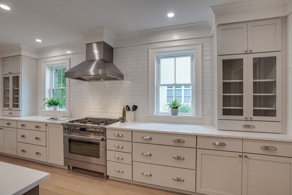 25 Webber Avenue Bedford, MA 01730 - Photo 4 of 42 a kitchen with stainless steel appliances a stove and white cabinets