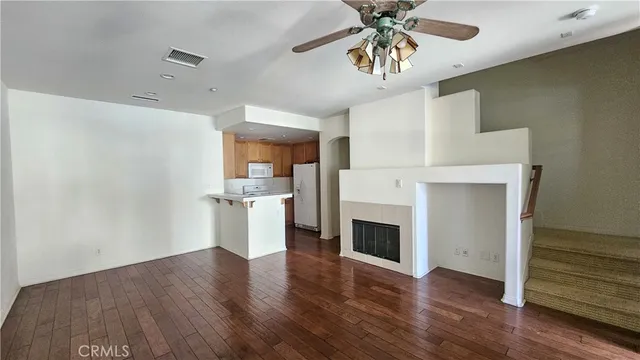 a view of a kitchen with a sink a refrigerator and wooden floor