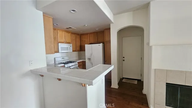 a kitchen that has a sink a microwave a refrigerator and a stove