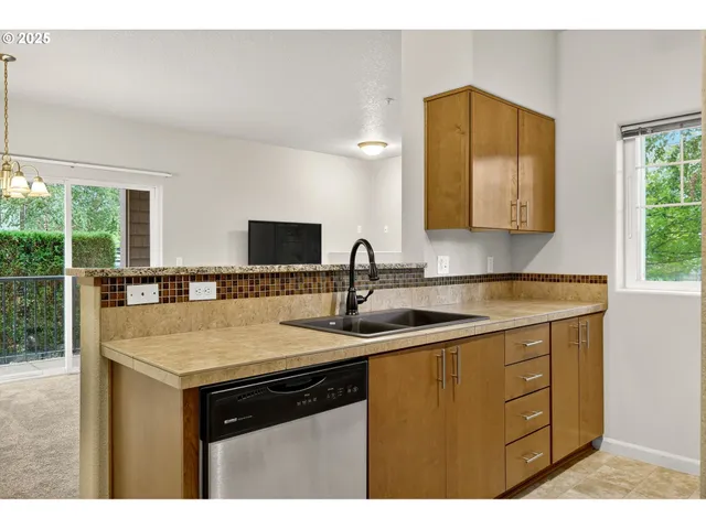a kitchen with a sink cabinets and a large window