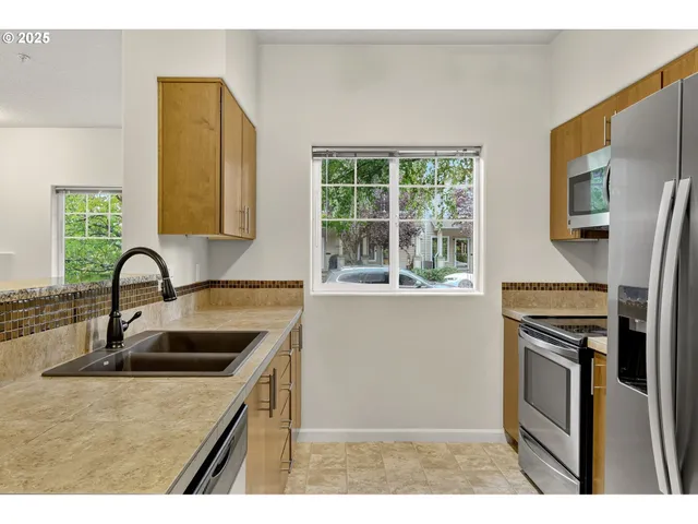 a kitchen with stainless steel appliances granite countertop a sink stove and refrigerator