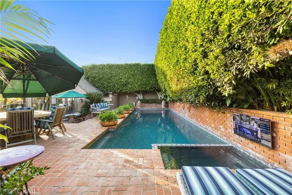 a view of a patio with a table and chairs under an umbrella