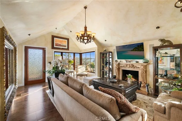 a living room with furniture a chandelier and a fireplace