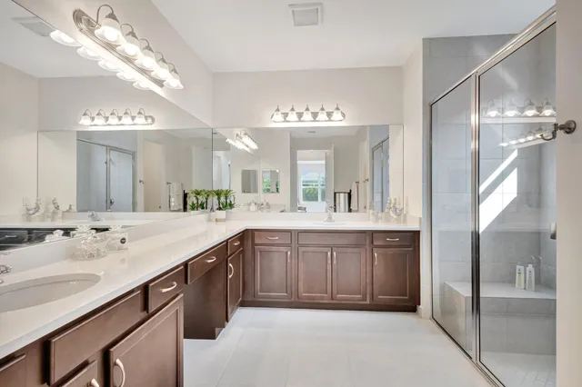 a spacious bathroom with a granite countertop sink a mirror and a shower