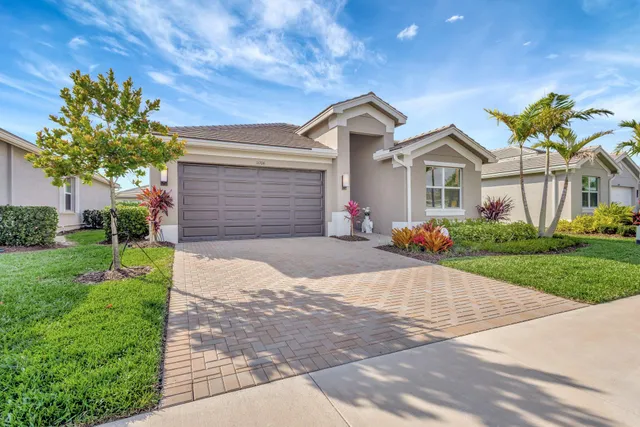 a front view of a house with a yard and a garage