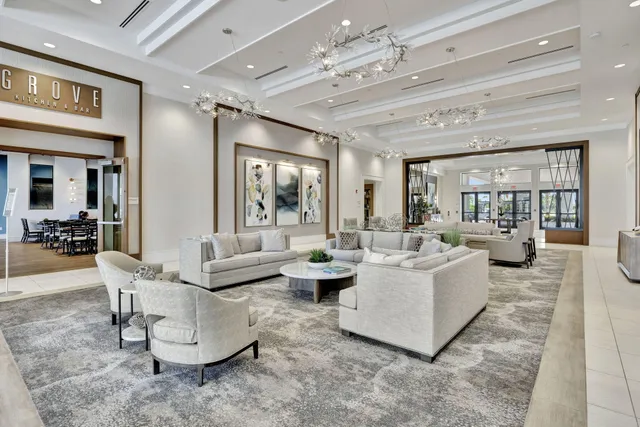 a living room with couches and kitchen view with wooden floor