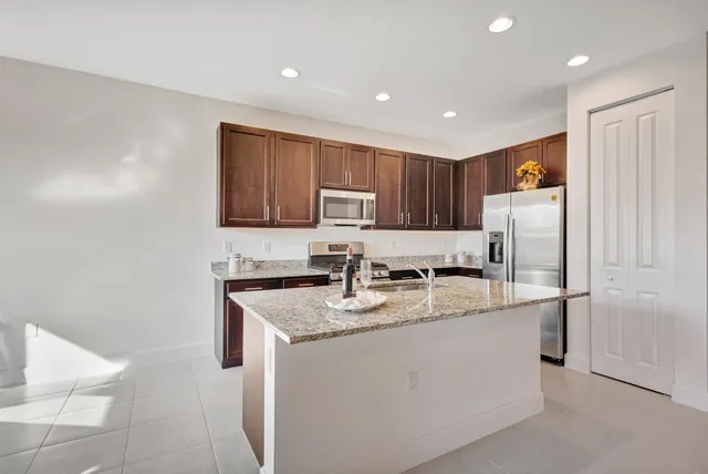 a kitchen with stainless steel appliances granite countertop a sink a stove a refrigerator a microwave and cabinets