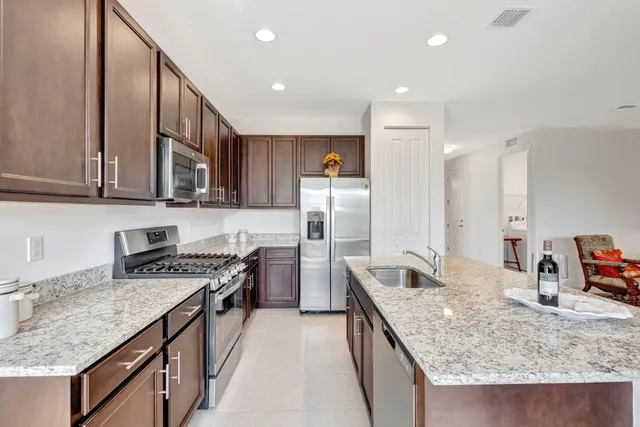 a kitchen with stainless steel appliances granite countertop a sink stove and refrigerator