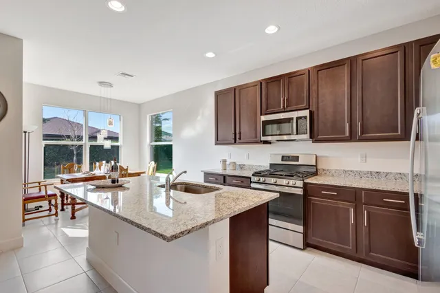 a kitchen with granite countertop stainless steel appliances a sink stove and microwave
