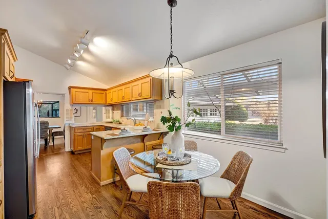a dining room with furniture a chandelier and wooden floor