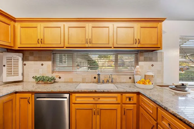 a kitchen with stainless steel appliances granite countertop a sink and cabinets