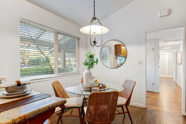 a dining room with furniture a potted plant and a chandelier