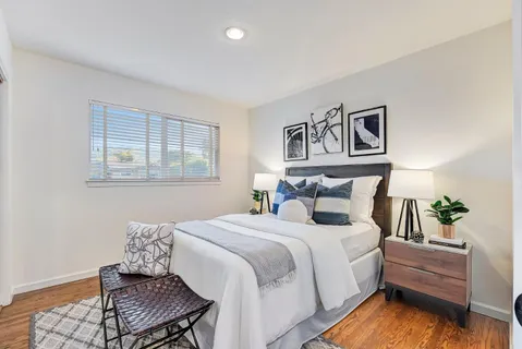 a bedroom with bed couch and window