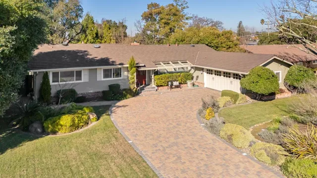 an aerial view of a house with swimming pool and porch