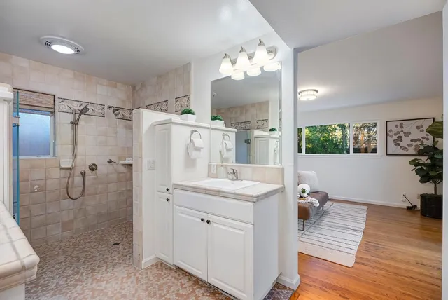 a spacious bathroom with a double vanity sink a mirror and a shower
