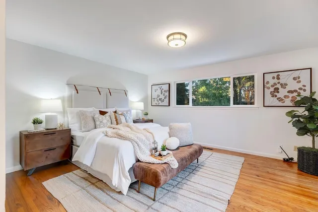 a bedroom with a bed and wooden floor
