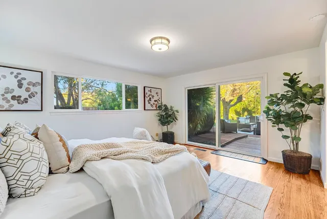 a bedroom with a large bed and a potted plant