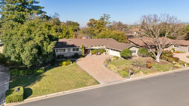 an aerial view of a house with a yard and lake view