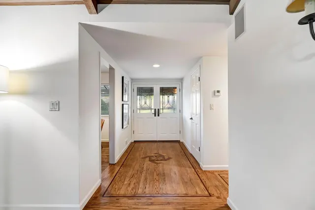 a view of a hallway with wooden floor