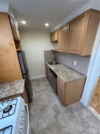 a kitchen with stainless steel appliances granite countertop a sink stove and refrigerator