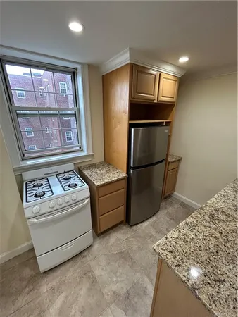 a kitchen with stainless steel appliances granite countertop a refrigerator and a stove top oven