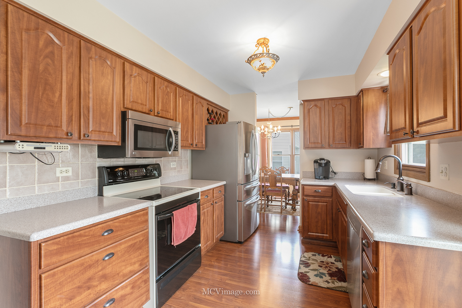 1991 Valley Road Lombard, IL 60148 - Photo 10 of 40 a kitchen with stainless steel appliances a stove a sink a microwave a refrigerator cabinets and a window